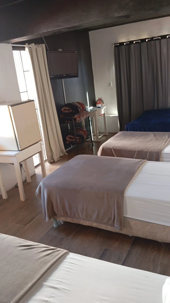 Quarto família com várias camas e TV